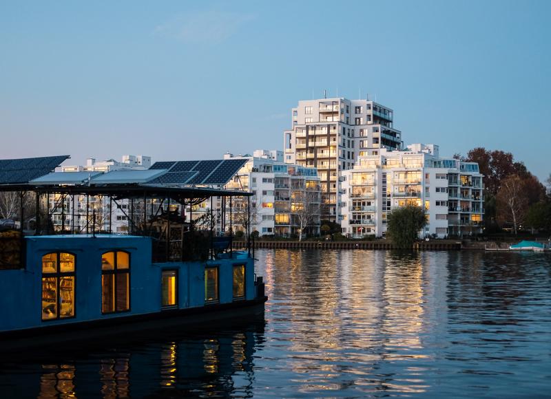 Wohnen am Wasser mit Hausboot im Vordergrund